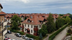 Asuinalue, jossa on useita taloja, joista osassa on harjakatto ja osassa tasakatto, ja alueen ympärillä on vehreää kasvillisuutta.