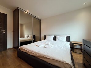 Een moderne hotelkamer met een groot bed, een kledingkast en een bureau.
