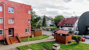 Ein Wohngebiet mit einem roten Gebäude, einer kleinen Backsteinstruktur und einer Satellitenschüssel.