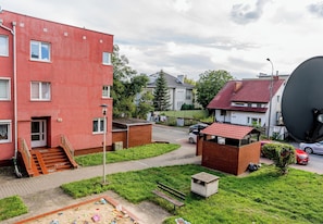 Un quartier résidentiel avec un immeuble rouge, une petite construction en briques et une antenne parabolique.