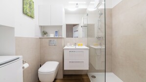 Ein kleines Badezimmer mit Toilette, Waschbecken und Dusche.
