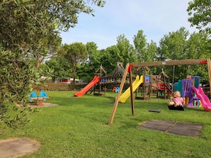 Ein Spielplatz mit Schaukeln, Rutschen und Klettergerüsten.
