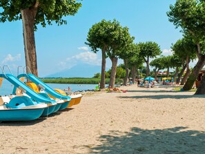 A beach with water slides, trees, and a clear sky. - Beautiful apartment in villa for 4 people with A/C, WIFI, pool, TV and terrace (Sirmione)