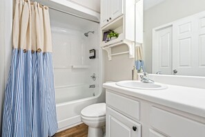 A bathroom with a bathtub, toilet, and sink. - Auburn - 3 King Beds - 3 Private Baths - Near Downtown AU!! (Auburn)