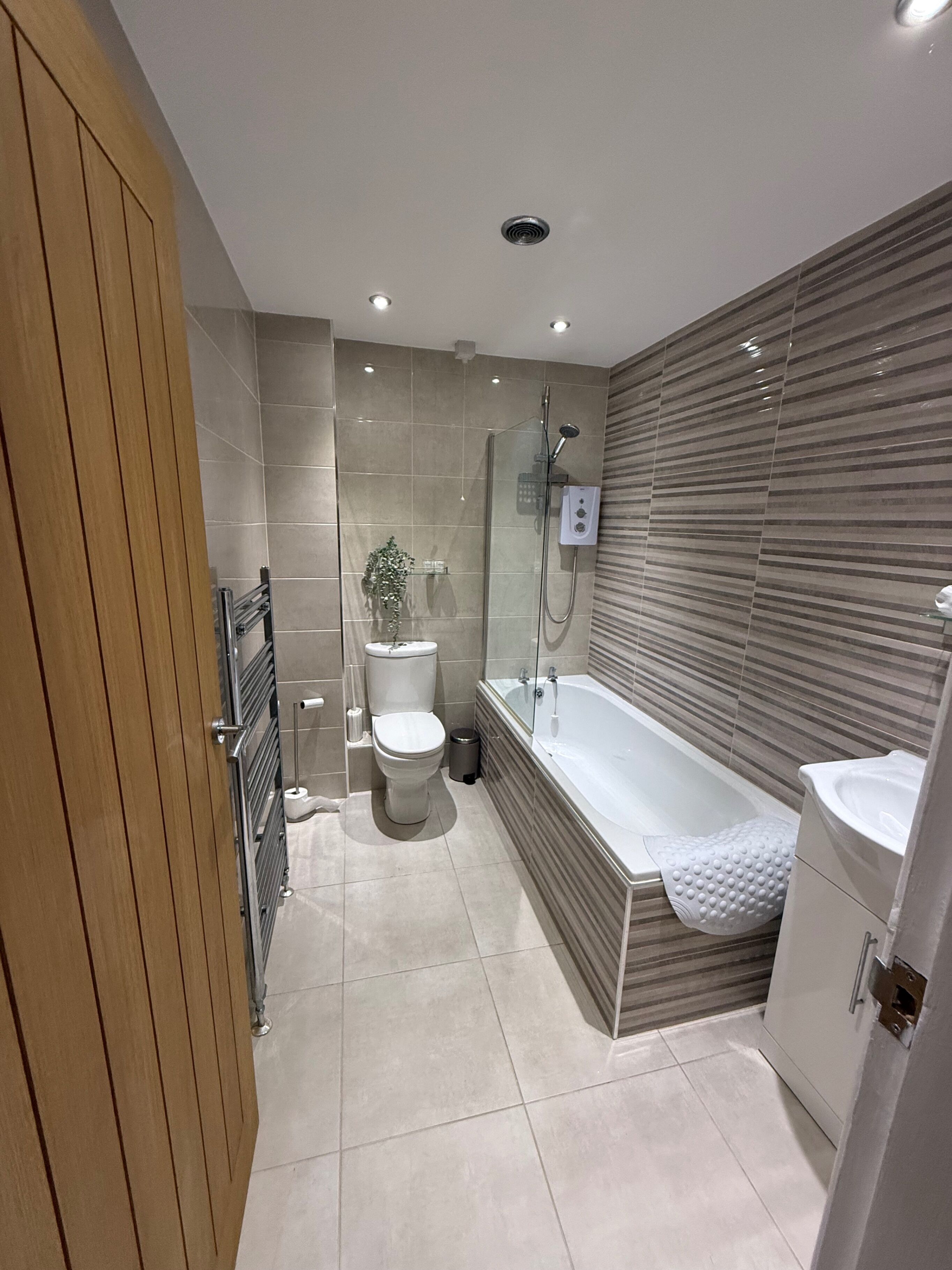 A modern bathroom with a shower, toilet, and bathtub.