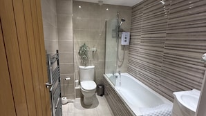 Un baño moderno con ducha, inodoro y bañera.
