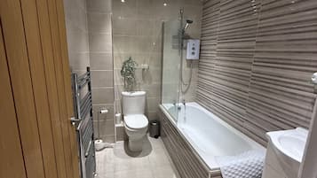 A modern bathroom with a shower, toilet, and bathtub.