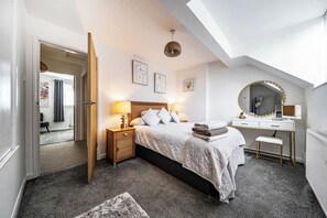 A bedroom with a bed, bedside tables, a desk, a mirror, and artwork on the walls. - House Sleeps 4 with Parking and Garden (Scunthorpe)