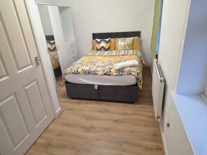 A bedroom with a bed, a wardrobe, and a radiator.