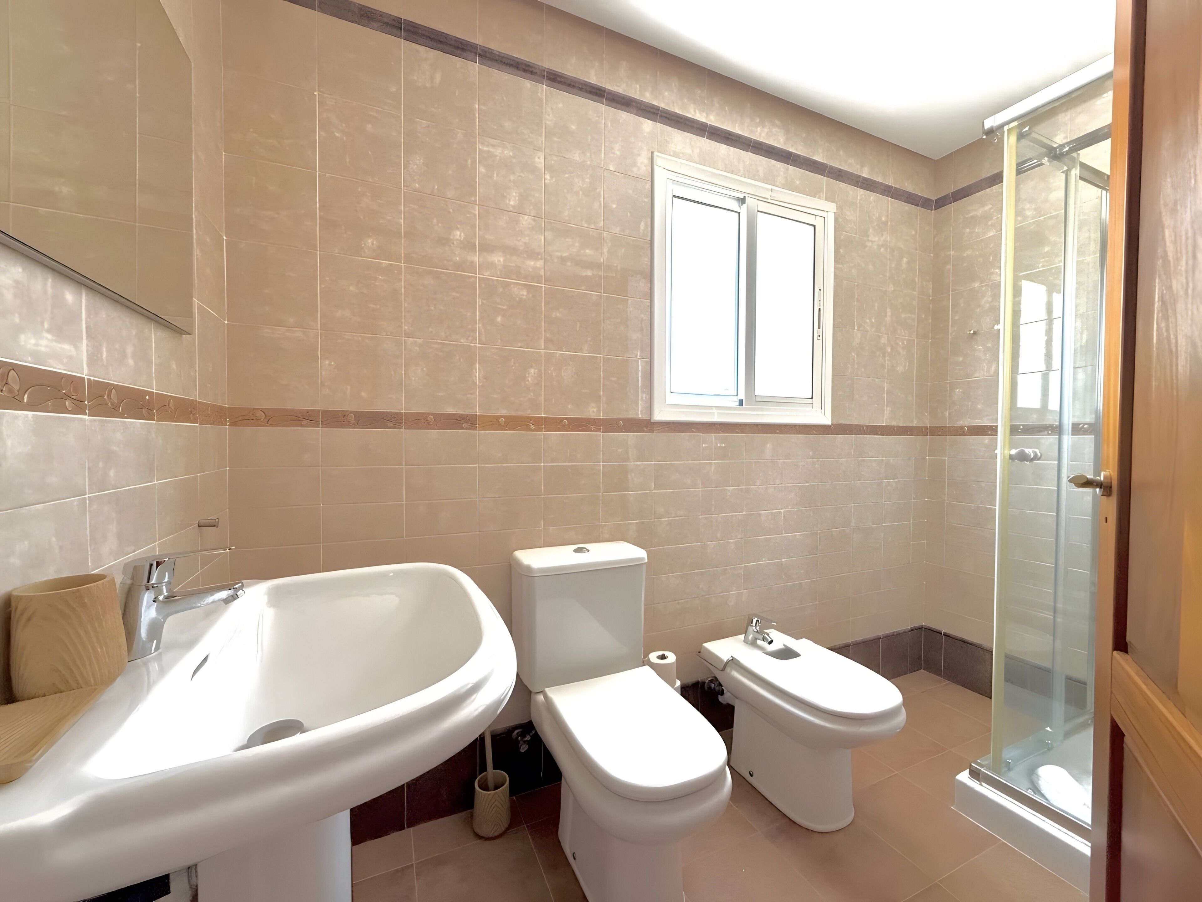 Een badkamer met een bad, toilet en douche.