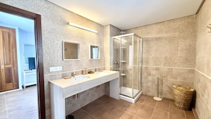 A modern bathroom with a glass shower enclosure, a double sink vanity, and a visible trash bin. - Can Alaya - Luxury Holiday Villa in Jesús, Ibiza with Views of Dalt Vila (Santa Eulària des Riu)