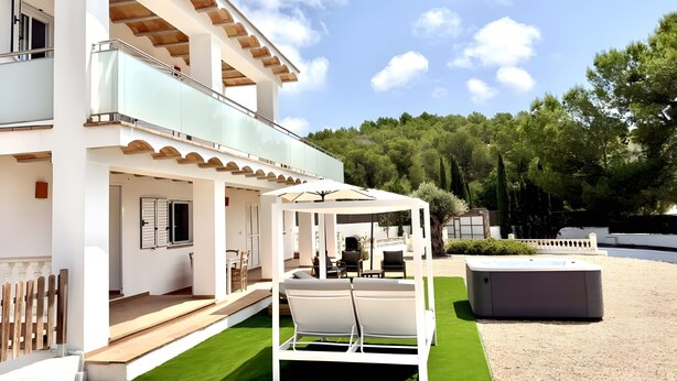 A two-story building with a covered outdoor seating area, a pool, and a well-maintained lawn. - Can Alaya - Luxury Holiday Villa in Jesús, Ibiza with Views of Dalt Vila (Santa Eulària des Riu)