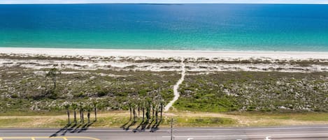 Une route côtière offrant une vue dégagée sur l’océan et la plage.