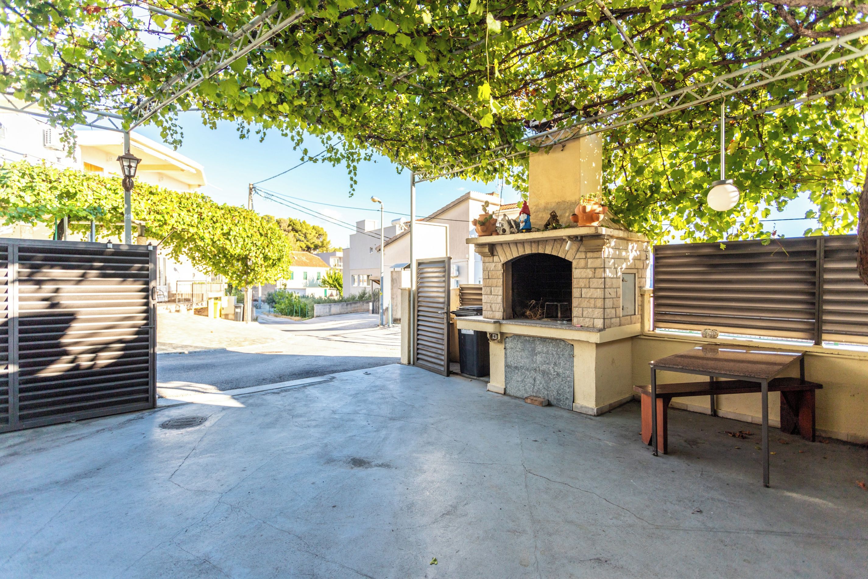 En udendørs patio med en mur oven, et bord og en stol.