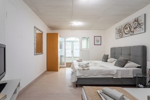 A modern bedroom with a large bed, a television, and a view to the outside. - A2 - Cozy apt w pool & big terrace, 2 min to beach (Dugi Rat)