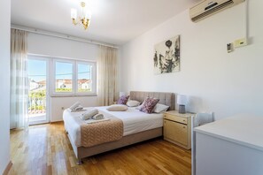 A bedroom with a bed, bedside table, lamp, and a painting on the wall. - A3 - Spacious apt w pool, terrace and sea view (Dugi Rat)