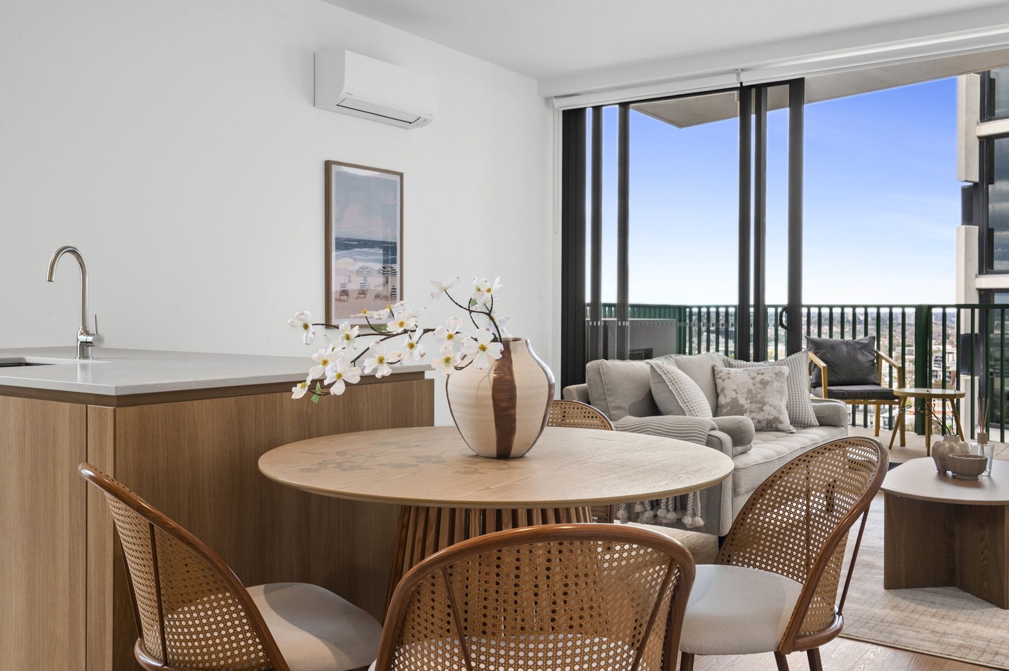 A modern apartment with a kitchen, dining area, and balcony.
