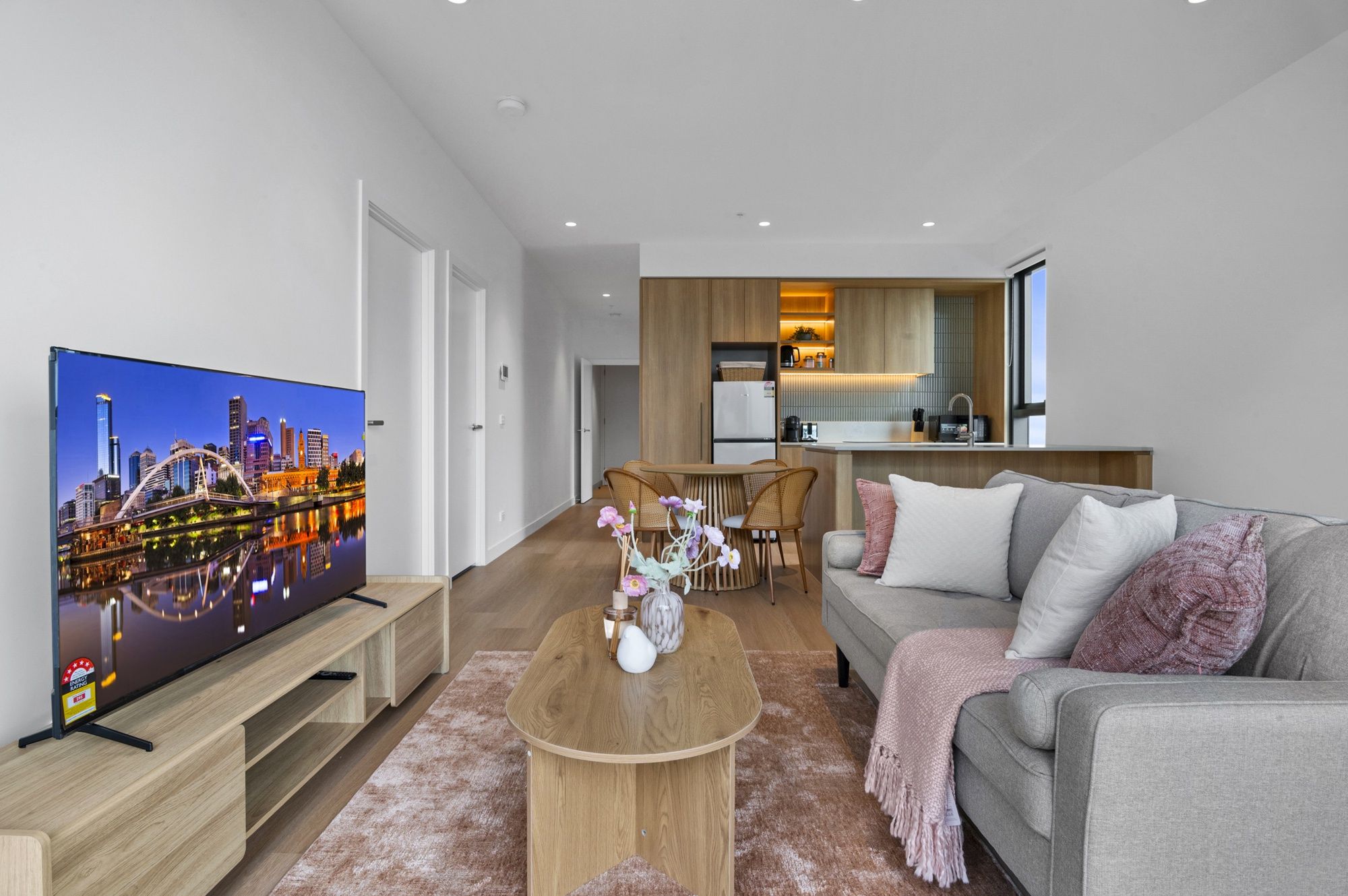 Ein modernes Wohnzimmer mit Flachbildfernseher, Couchtisch und Sofa.
