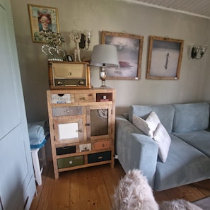 A living room with a vintage radio, a lamp, and a sofa.
