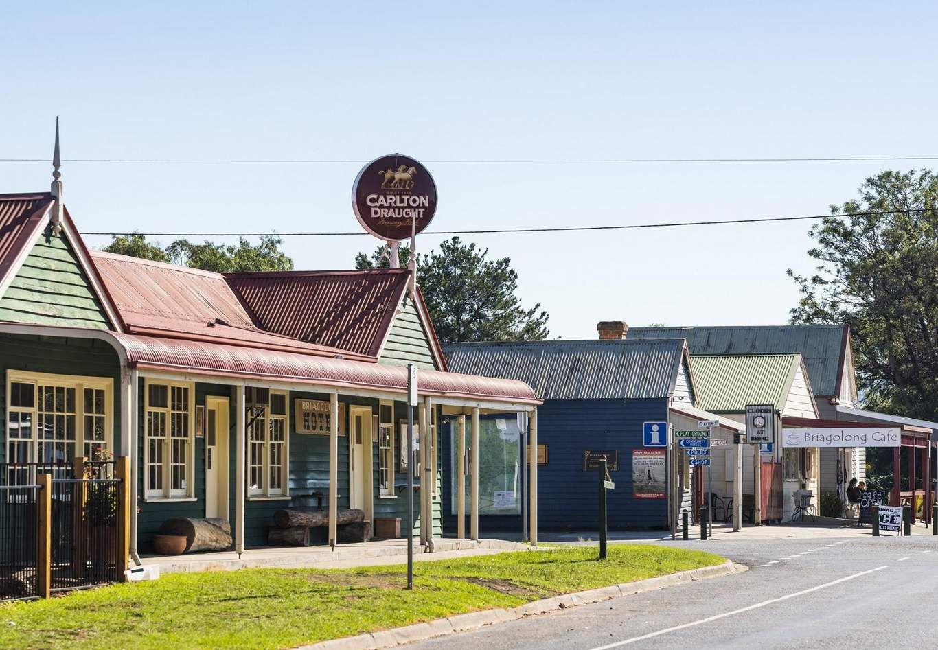 A historic building with a sign for Carlton Draught Hotel, a covered outdoor seating area, and a cafe named Briagolong Cafe.