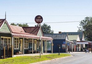A historic building with a sign for Carlton Draught Hotel, a covered outdoor seating area, and a cafe named Briagolong Cafe.