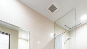 A bathroom with a toilet, a shower, and a sink with soap dispensers. - The Florence Venice Mall Modern 1BR w/Balcony View (Taguig)