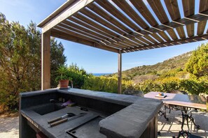 An outdoor grill area with a view of the hills and ocean. - Holiday Home 'La Bergerie' with Sea View, Wi-Fi and Air Conditioning (Bonifacio)