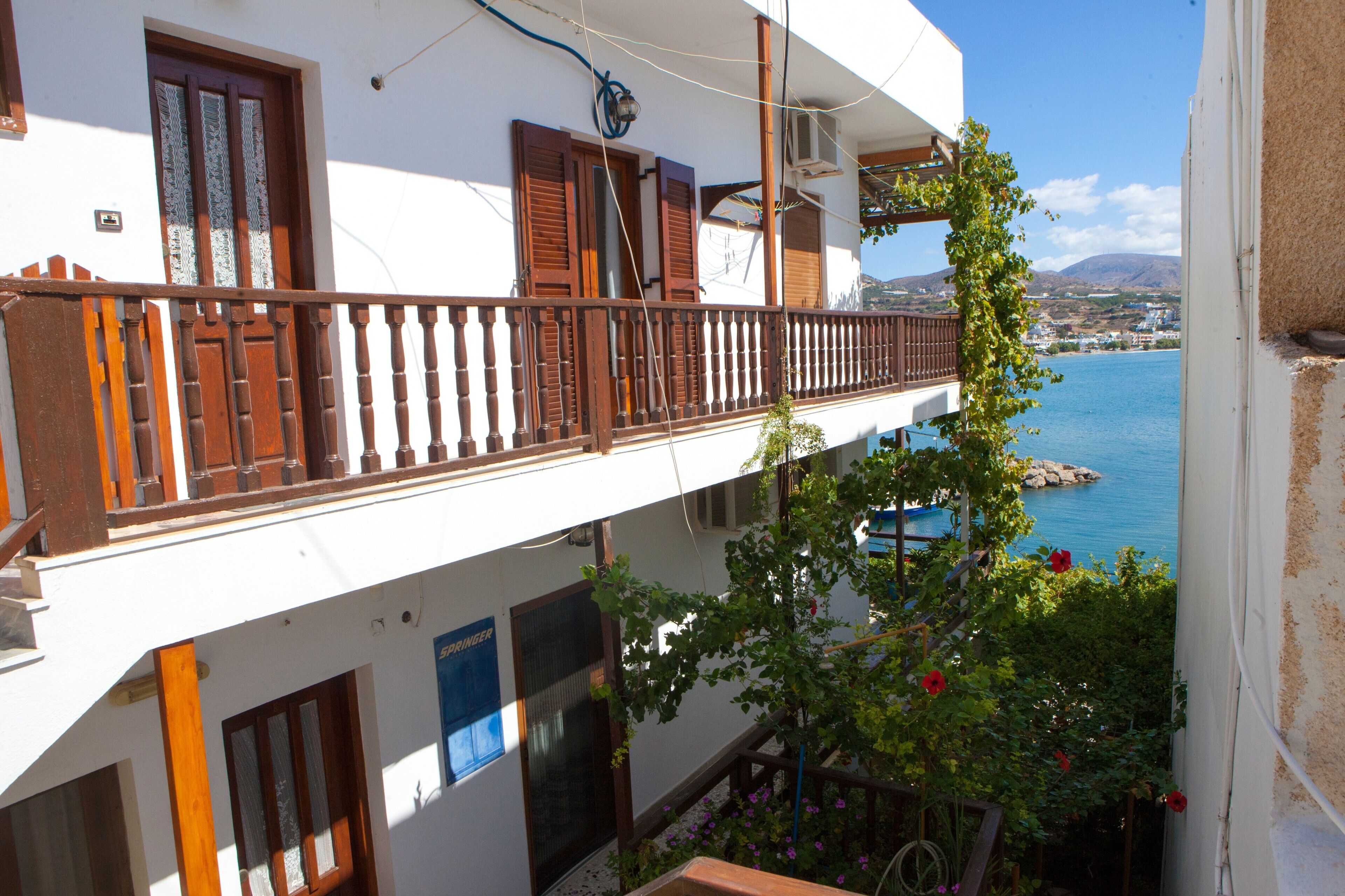 A two-story building with a balcony overlooking a body of water.