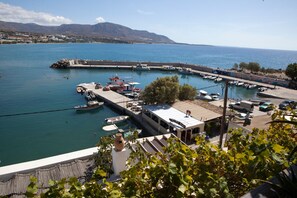 Un puerto deportivo con barcos amarrados, un muelle y montañas al fondo.