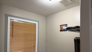 Un baño con ventana, un perchero y un cuadro en la pared.