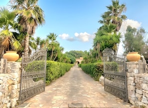 A paved pathway leading to a gated entrance with stone walls and decorative metal gates. - SeaShell – Salento Retreat: Private Pool, Wi-Fi & A/C, 1 km from the Sea (Corsano)