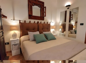 A bedroom with a large bed, two bedside tables, a mirror, and a wall-mounted light fixture. - SeaShell – Salento Retreat: Private Pool, Wi-Fi & A/C, 1 km from the Sea (Corsano)