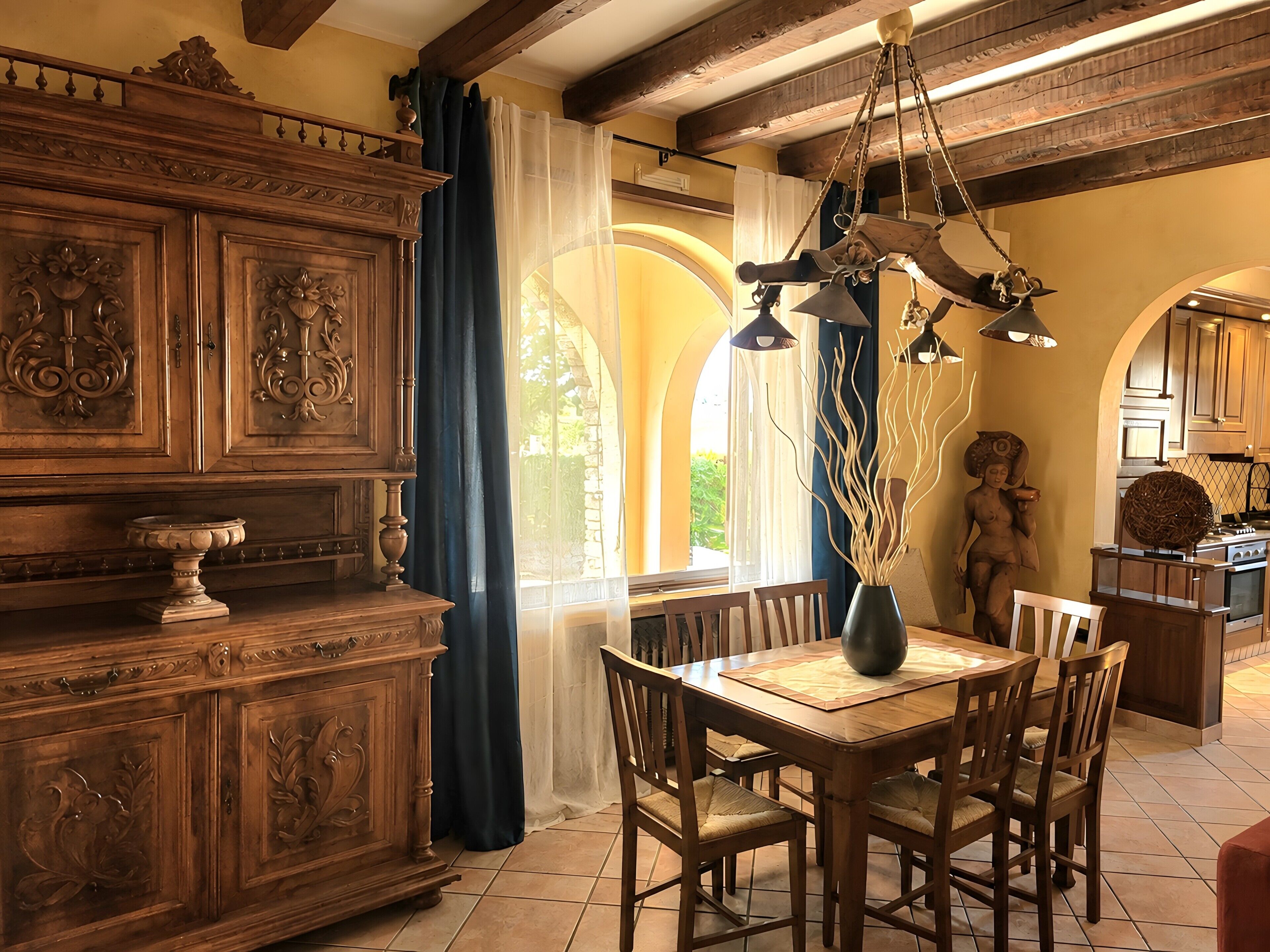 A dining area with a wooden table, chairs, and a chandelier.