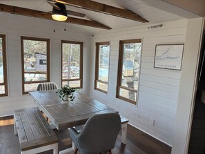 Ein Essbereich mit Holztisch, Stühlen und Deckenventilator.