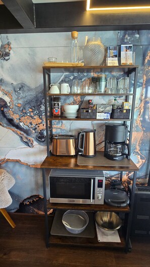 A kitchen with a marble backsplash, stainless steel appliances, and a coffee maker on a shelf. - Houseboat 'Hafensuite Rügen' with Wi-Fi and Panoramic Views on Rügen Island (Sagard)