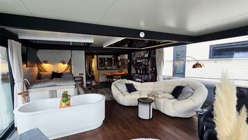 Un intérieur moderne avec une grande baignoire, un canapé et un coin repas.