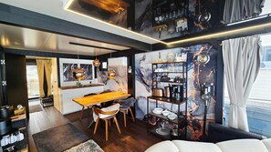 A modern kitchen with a wooden countertop, hanging pendant lights, and a marble backsplash.