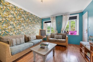 A living room with two sofas, a coffee table, and a bookshelf. - Hill crest farmhouse (Vengeons)