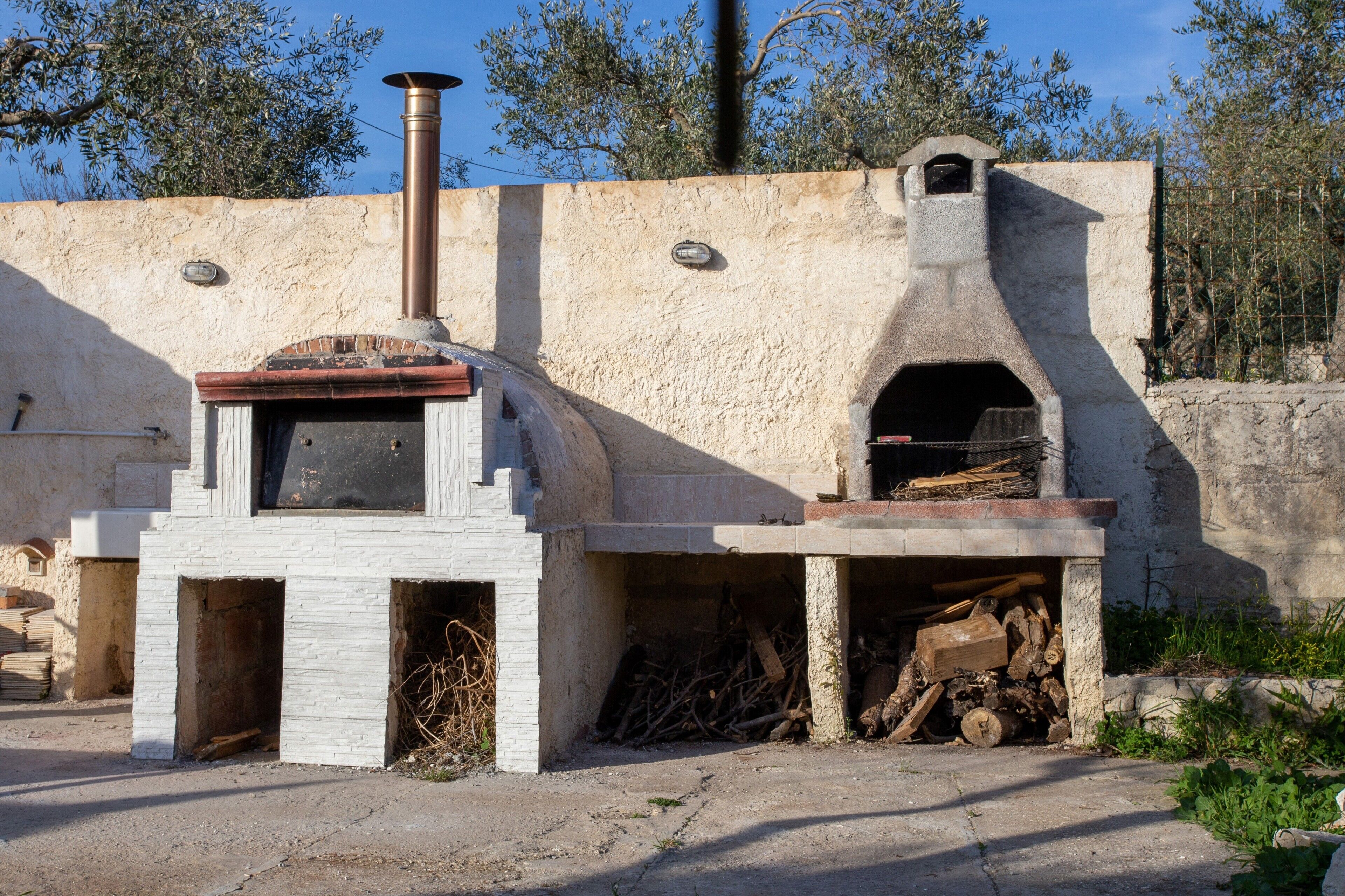 A traditional brick oven with a chimney, a small window, and a door.