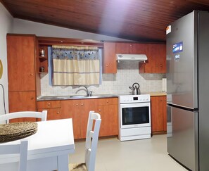 A kitchen with wooden cabinets, a white stove, and a stainless steel refrigerator.