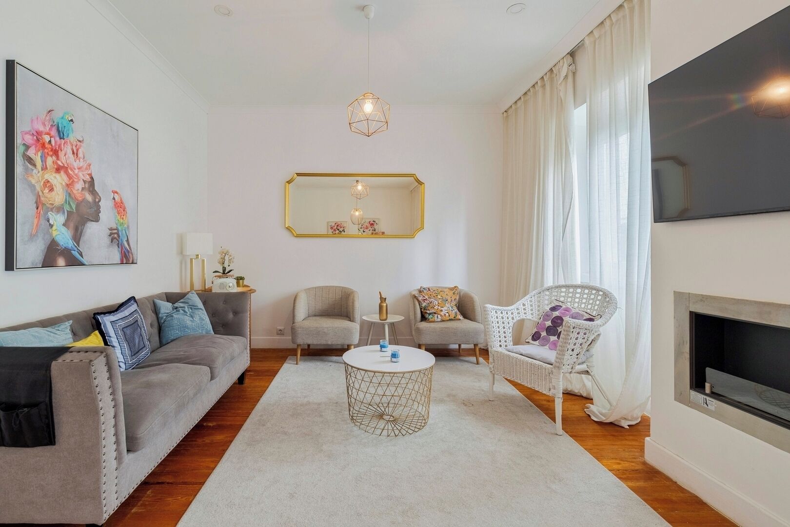 A living room with a sofa, armchairs, a coffee table, and a fireplace.
