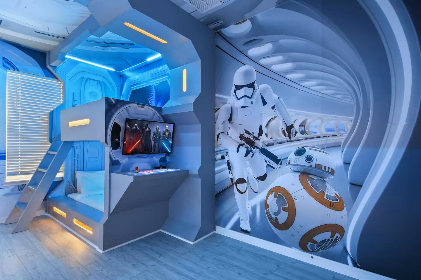 A room with a Star Wars theme, including a large mural of a Stormtrooper and a TIE fighter, a gaming console, and a seating area with a view of the room.