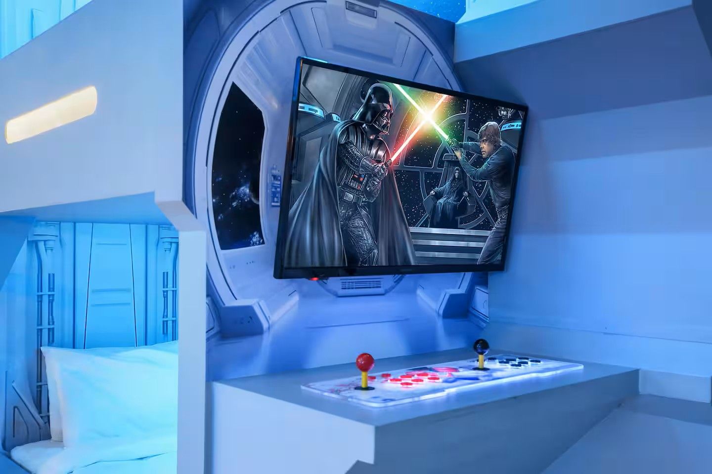 A room with a large screen displaying a Star Wars scene, a gaming console, and a futuristic design.