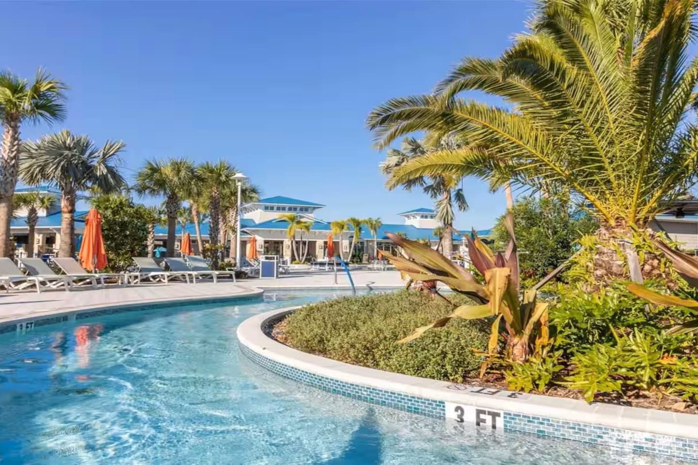 Une piscine dont la profondeur maximale est indiquée à 3 pieds, entourée de palmiers et de chaises longues.
