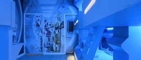 A room with a futuristic design, featuring geometric shapes and a central display of Star Wars characters.