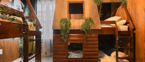 A cozy cabin-style room with bunk beds, a small window, and wooden walls.