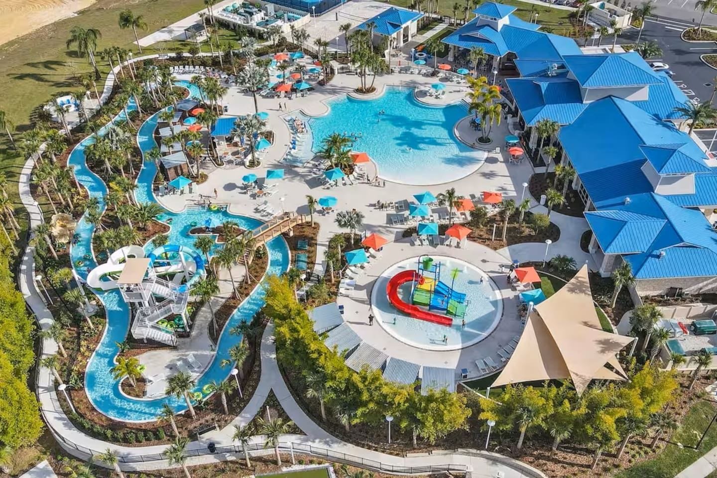 An aerial view of a resort with multiple swimming pools, water slides, and lounge areas.