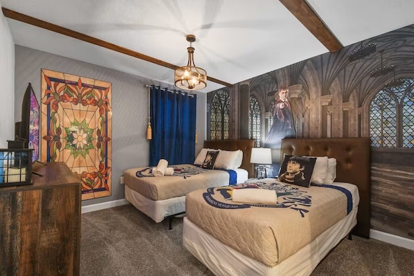 Een hotelkamer met twee bedden, een glas-in-loodraam en een muurschildering in gotische stijl.