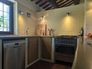 A kitchen with a dishwasher, wooden cabinets, a stove, and a window. - Holiday Home 'Alloro' with Mountain View, Private Pool and Wi-Fi (Pergola)