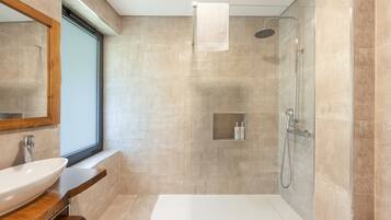 Een moderne badkamer met een bad, een douche en een wastafel met spiegel.